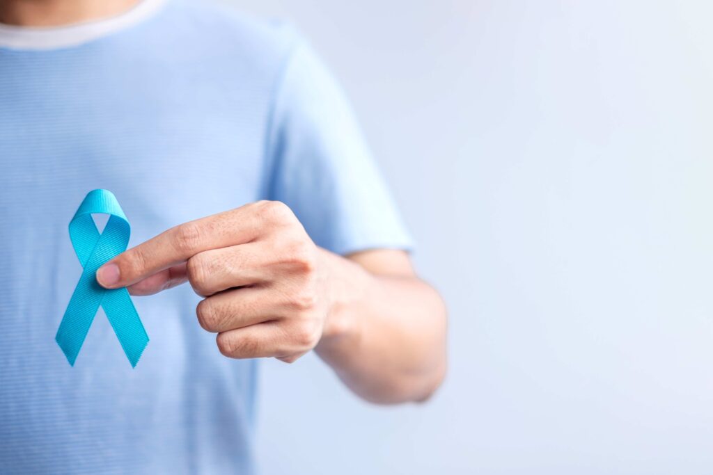Homem segurando a fitinha do Novembro Azul que conscientiza sobre a saúde masculina